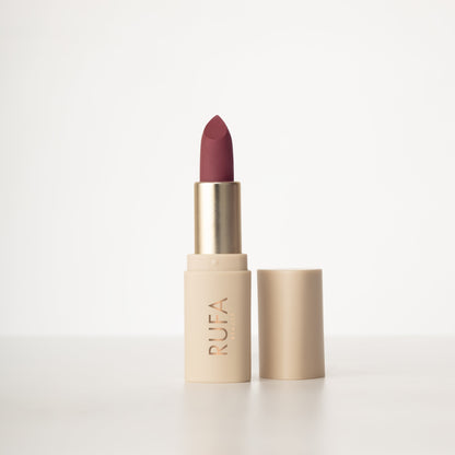 A matte lipstick in a bullet container, with the brand name 'RUFA' inscribed on it. The color of the lipstick is muted pink